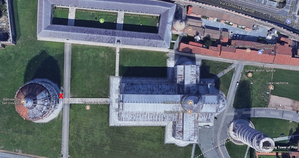 The Baptistry of St. John (Battistero di San Giovanni) faces the Cathedral of Pisa across the Piazza del Duomo. The Leaning Tower of Pisa is at the eastern end of the complex. The red X marks the place the young vendor sits.