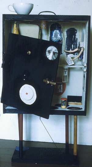 The Alchemist's Valise by Fran Moyer (front, door closed), A cabinet assemblage of polychrome wood and found objects (64"), 1963.